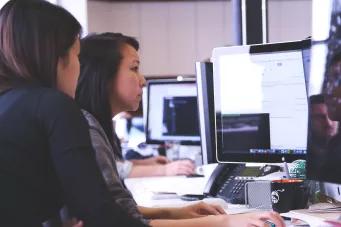 Photo de deux femmes qui travaillent devant un écran