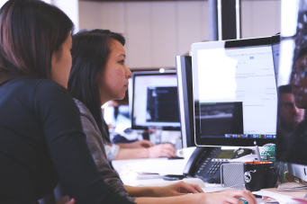 Photo de deux femmes qui travaillent devant un écran