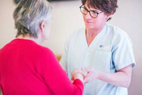 Photo d'une infirmière tenant les mains d'une personne âgée