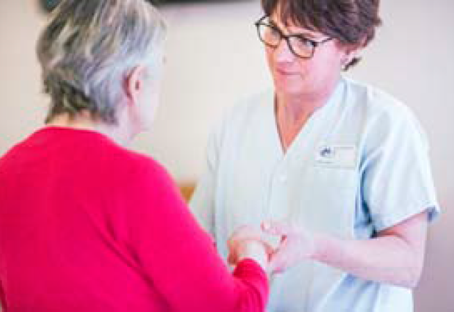 Photo d'une infirmière tenant les mains d'une personne âgée