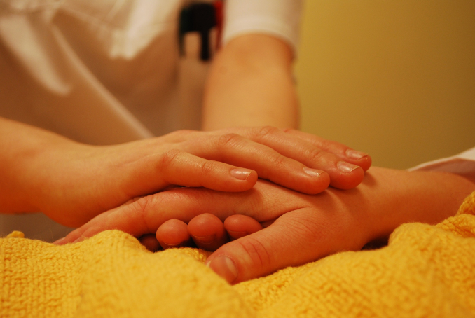 Gros plan de mains d'un médecin prenant les mains d'un patient