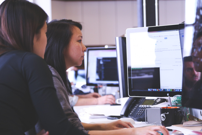 Photo de deux femmes qui travaillent devant un écran