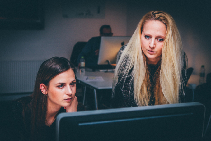 Photo de deux femmes qui travaillent devant un écran