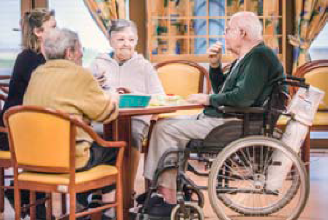 Photo d'un groupe de personnes âgées autour d'une table dans un établissement hébergeant des personnes âgées dépendantes