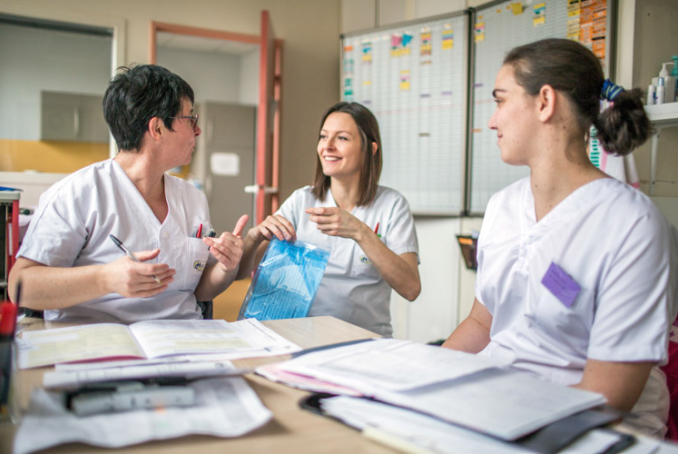 Photo de trois professionnelles de santé, exerçant à l'hôpital, en réunion dans une salle de travail